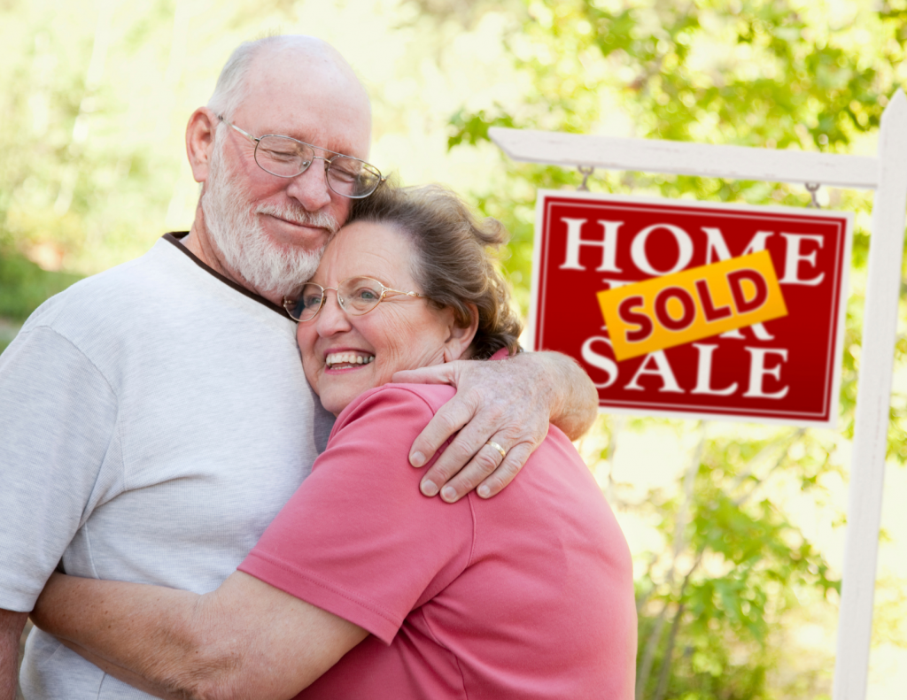 Couple standing next to a sold house
