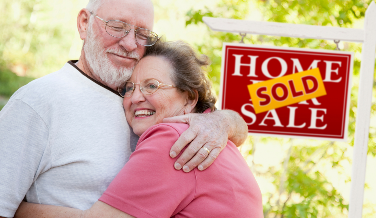 Couple standing next to a sold house